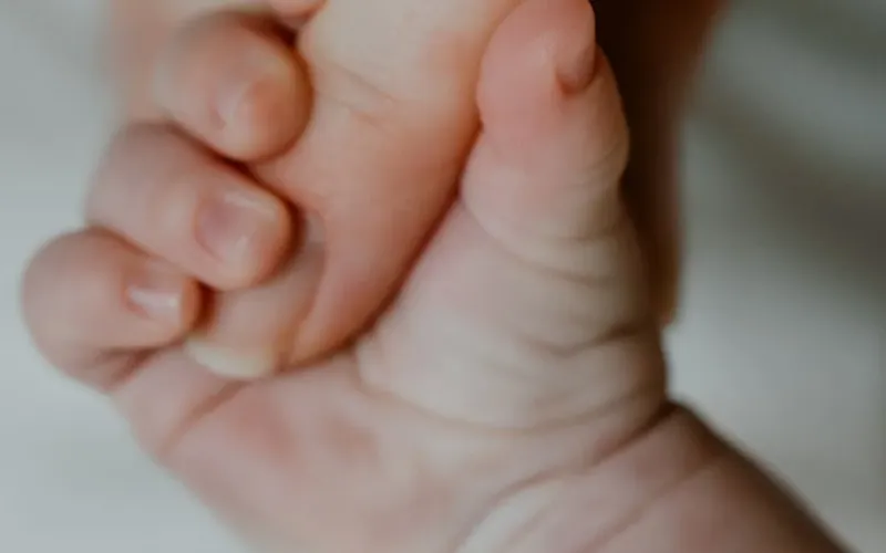 Main d'un adulte et d'un premature