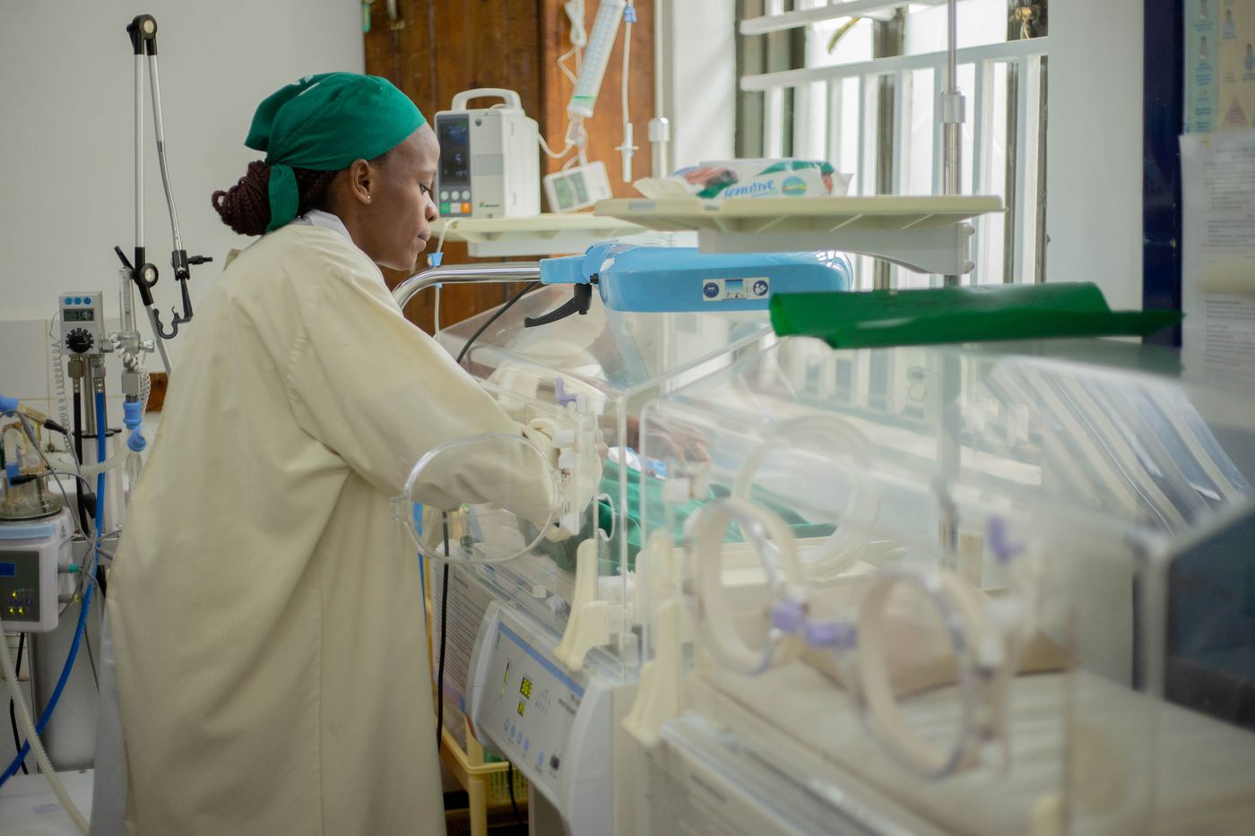 Soignante aupres d'un bebe en couveuse, service de neonatologie